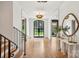 Bright foyer with hardwood floors, decorative lighting, staircase, and marble accent table at 2215 Cortelyou Rd, Charlotte, NC 28211