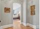 Hallway leading to a bedroom, features hardwood floors and neutral walls at 2215 Cortelyou Rd, Charlotte, NC 28211