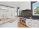 Gourmet kitchen featuring custom cabinetry, stainless steel appliances, and black tile backsplash at 2215 Cortelyou Rd, Charlotte, NC 28211
