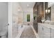 Long main bathroom features a white marble floor, soaking tub, and and vanities at 2215 Cortelyou Rd, Charlotte, NC 28211