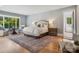 Bright main bedroom boasts hardwood floors, area rug, sitting area and access to main bathroom at 2215 Cortelyou Rd, Charlotte, NC 28211