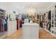 Spacious walk-in closet features hardwood floors, closet island, and custom shelving at 2215 Cortelyou Rd, Charlotte, NC 28211