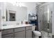 Bright bathroom featuring a gray vanity, toilet, and tiled shower with glass door at 250 Winford Rd, Troutman, NC 28166