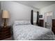 Bedroom featuring a floral-patterned bedspread, side tables, and a view into the bathroom at 250 Winford Rd, Troutman, NC 28166