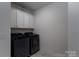 Bright laundry room features overhead cabinets, washer and dryer at 250 Winford Rd, Troutman, NC 28166