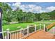 Backyard view showing a large, well-maintained lawn, a wooden deck, and lush landscaping on a sunny day at 2525 Saddlehorse Ln, Gastonia, NC 28056