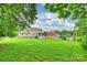 Exterior shot showcasing a spacious backyard with green lawn, home exterior, patio, and mature trees at 2525 Saddlehorse Ln, Gastonia, NC 28056
