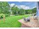 Beautifully landscaped backyard with patio area featuring a well-manicured lawn and mature trees on a bright day at 2525 Saddlehorse Ln, Gastonia, NC 28056