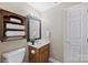 Cozy bathroom with wood vanity, framed mirror, and decorative shelving for ample storage at 2525 Saddlehorse Ln, Gastonia, NC 28056