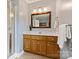 Bathroom featuring wood vanity, a framed mirror, a walk-in shower, and tiled floors at 2525 Saddlehorse Ln, Gastonia, NC 28056