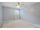 Empty bedroom with blue walls, carpet, ceiling fan, and large window at 2525 Saddlehorse Ln, Gastonia, NC 28056