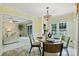 Sunny dining area with decorative chandelier, large windows and view into the adjacent living room at 2525 Saddlehorse Ln, Gastonia, NC 28056