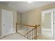 Upstairs hallway with carpet and wood railing leading to bedrooms at 2525 Saddlehorse Ln, Gastonia, NC 28056