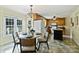 Eat-in kitchen with oak cabinets, tile flooring, a chandelier, and a breakfast area with a view at 2525 Saddlehorse Ln, Gastonia, NC 28056