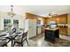 Functional kitchen with oak cabinets, an island, neutral tile flooring, and a breakfast area at 2525 Saddlehorse Ln, Gastonia, NC 28056