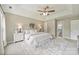 Bright main bedroom with tray ceiling, ceiling fan, carpet, two windows and decorative furniture at 2525 Saddlehorse Ln, Gastonia, NC 28056