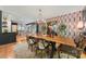 Open-concept dining room featuring a wooden table, stylish chairs, and colorful wallpaper near the modern kitchen at 26 New River Trce, Lake Wylie, SC 29710