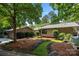 Well-maintained home exterior with manicured lawn, rock features and lush, mature landscaping at 26 New River Trce, Lake Wylie, SC 29710