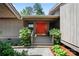Inviting front entrance with a vibrant red door, stone walkway, and lush greenery for added privacy at 26 New River Trce, Lake Wylie, SC 29710