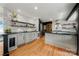 Bright kitchen with white cabinets, black countertops, stainless steel appliances, and hardwood floors at 26 New River Trce, Lake Wylie, SC 29710