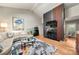 Cozy living room with a fireplace, modern TV, hardwood floors, and comfortable seating at 26 New River Trce, Lake Wylie, SC 29710