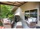 Cozy covered patio with comfortable seating, grill, and wooded views for outdoor relaxation and entertaining at 26 New River Trce, Lake Wylie, SC 29710