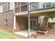 Exterior view of the home's backyard with brick walls, a covered patio, and stairs at 2695 Queens Rd, Lincolnton, NC 28092