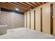 Unfinished basement featuring exposed ceiling beams, stone accent wall, and a blank canvas for customization at 2695 Queens Rd, Lincolnton, NC 28092