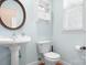 Powder room with pedestal sink and round mirror at 2695 Queens Rd, Lincolnton, NC 28092