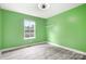 This bedroom is painted in light-green and has a single window and hardwood floors at 2695 Queens Rd, Lincolnton, NC 28092