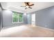 Spacious primary bedroom with a large window and neutral carpet and a view to the ensuite bath at 2695 Queens Rd, Lincolnton, NC 28092