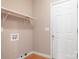 Bright laundry room featuring a shelf for storage, washer/dryer hookups, and a door leading outside at 2695 Queens Rd, Lincolnton, NC 28092
