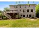 Large backyard with a deck, stairs, and lush greenery surrounding the brick house at 2857 Scarborough Ct, Gastonia, NC 28054