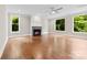 Bright living room featuring a fireplace, hardwood floors, large windows, and a ceiling fan at 2857 Scarborough Ct, Gastonia, NC 28054