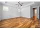 Spacious bedroom featuring hardwood floors, a ceiling fan, and three bright windows at 3008 Laney Pond Rd, Matthews, NC 28104