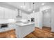 Modern kitchen with white cabinets, stainless appliances, and a sleek island with a built in sink at 3008 Laney Pond Rd, Matthews, NC 28104