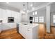 Open-concept kitchen with white island and adjacent living area filled with natural light at 3008 Laney Pond Rd, Matthews, NC 28104