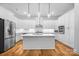 Modern kitchen with stainless steel appliances, white cabinetry, and a center island with countertop seating at 3008 Laney Pond Rd, Matthews, NC 28104