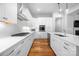 Modern kitchen with white cabinets, stainless steel appliances, gas cooktop, and hardwood floors at 3008 Laney Pond Rd, Matthews, NC 28104