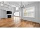 Sunlit living room with hardwood floors, fireplace, and contemporary lighting fixtures at 3008 Laney Pond Rd, Matthews, NC 28104