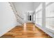 Open living room with hardwood floors, tall windows, and a staircase at 3008 Laney Pond Rd, Matthews, NC 28104