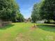 Lush backyard featuring mature trees and a quaint storage shed at 302 Melinda Ave, Kannapolis, NC 28083