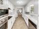 A galley kitchen features all-white cabinetry and stainless steel appliances at 302 Melinda Ave, Kannapolis, NC 28083