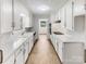 Bright galley kitchen with all-white cabinetry and a view to another room at 302 Melinda Ave, Kannapolis, NC 28083