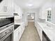 A galley kitchen features all-white cabinetry and stainless steel appliances at 302 Melinda Ave, Kannapolis, NC 28083
