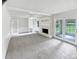 Bright, spacious living room featuring a fireplace with built-in shelving and access to the sunroom at 302 Melinda Ave, Kannapolis, NC 28083