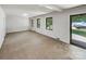Bright living room with three large windows and a glass door to the right, showing outdoor views at 302 Melinda Ave, Kannapolis, NC 28083
