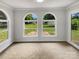 Cozy sunroom with bright, natural light filtering through arched windows overlooking backyard at 302 Melinda Ave, Kannapolis, NC 28083