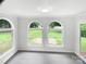 Cozy sunroom with natural light streaming through the arched windows overlooking backyard at 302 Melinda Ave, Kannapolis, NC 28083