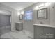 Bright bathroom features gray vanities with marble-style tile floors at 3800 Lovett Cir, Charlotte, NC 28210